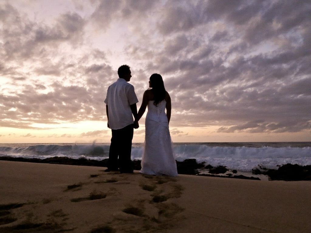 Couple at sunset holding hands on beach