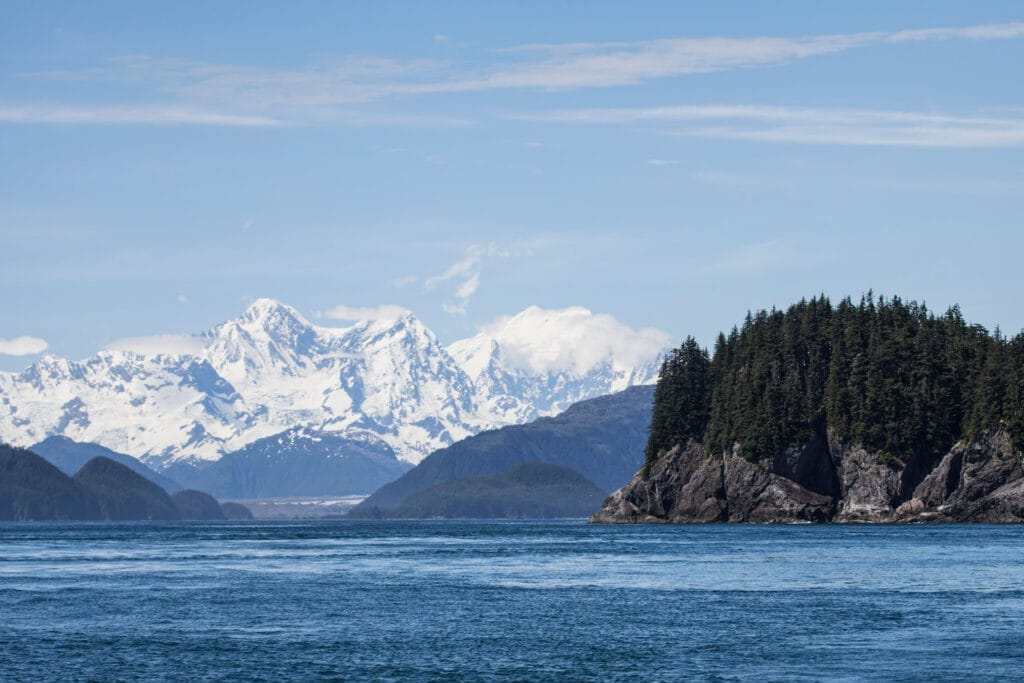 Snowy mountains with a lake and trees in front